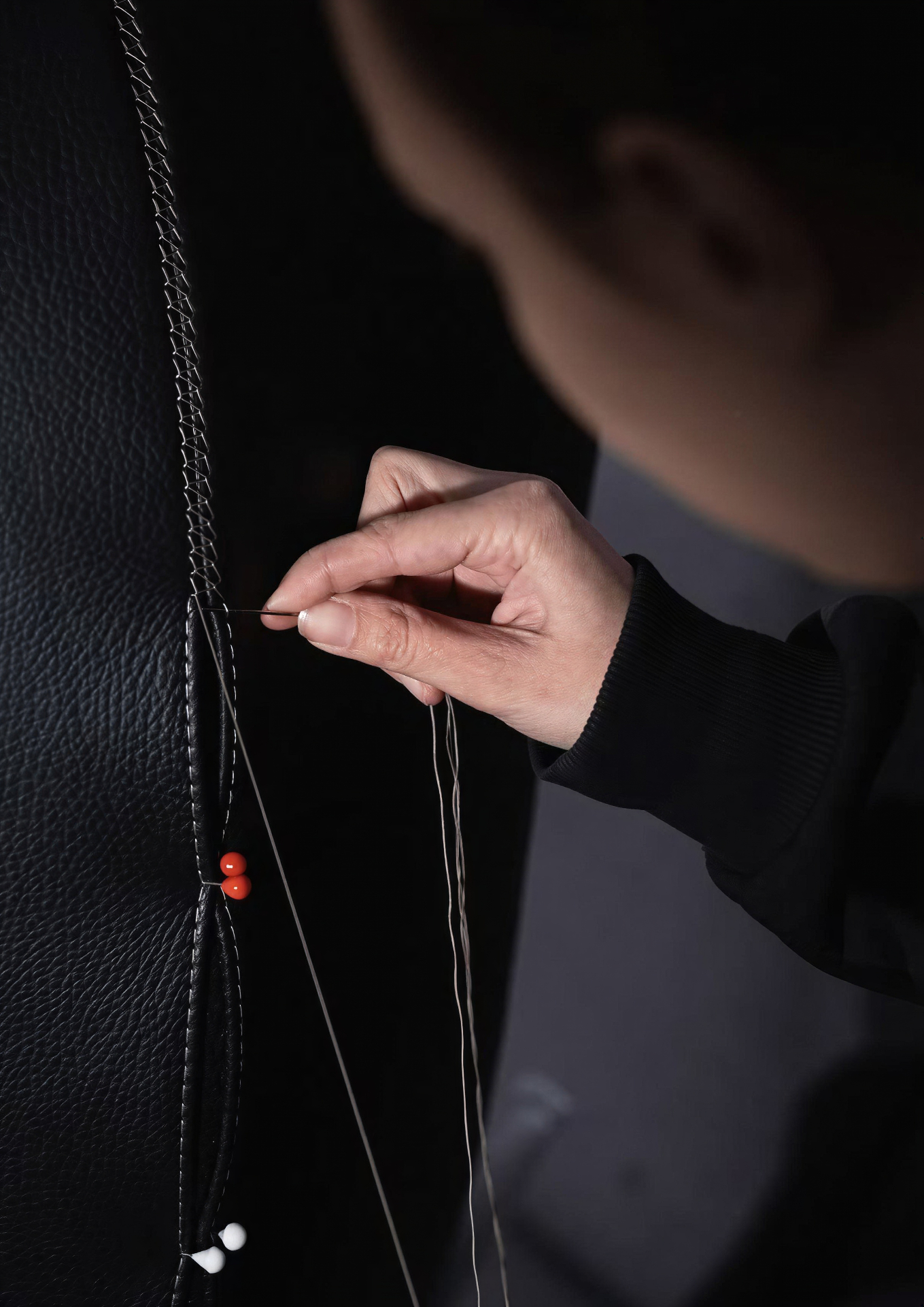 Cucitura a mano su rivestimento in pelle nera